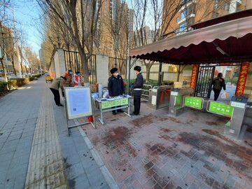 Wolontariusze sprawdzający temperaturę mieszkańców osiedla w Pekinie