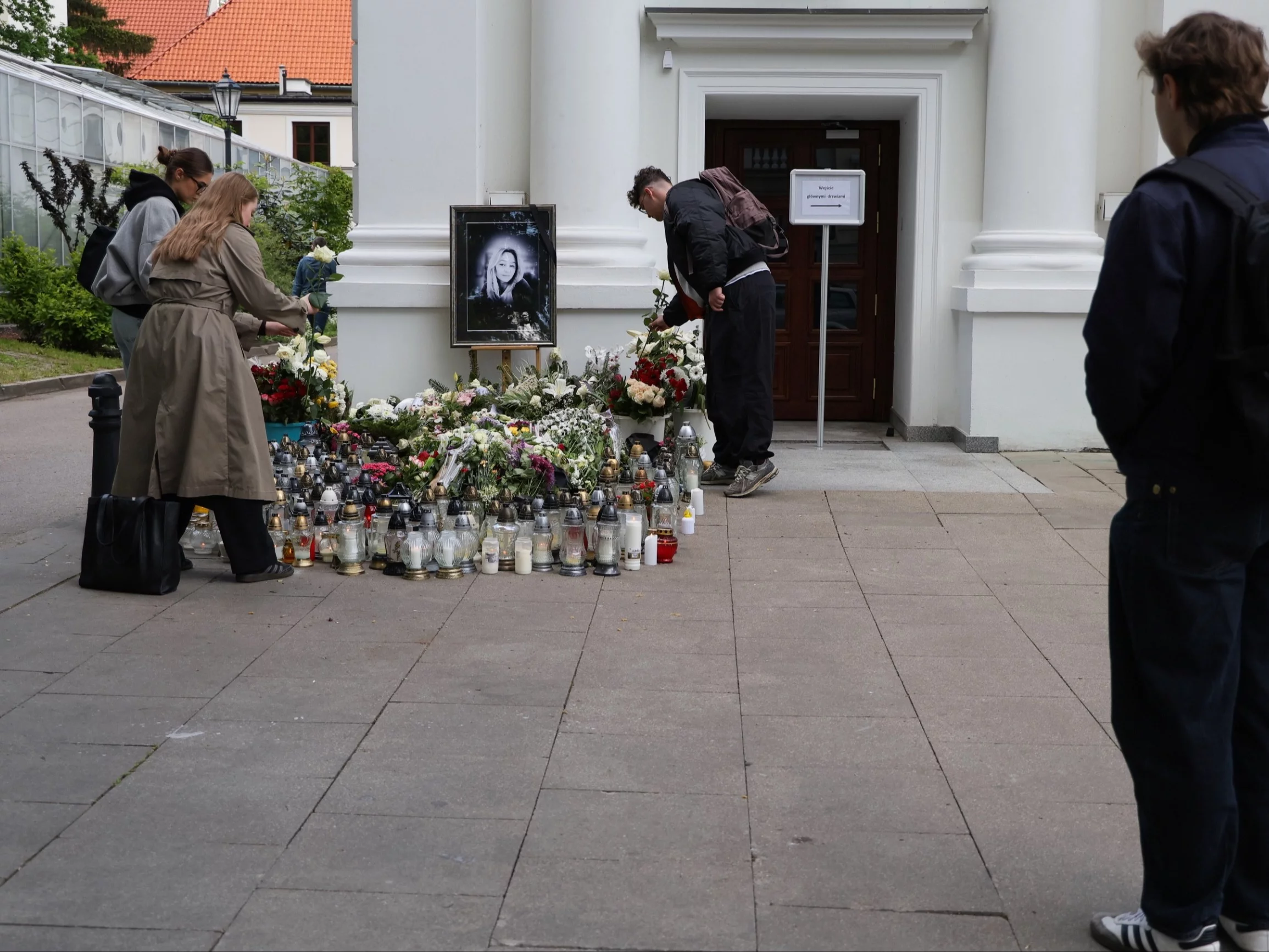 Znicze pod zdjęciem zabitej kobiety, przed budynkiem Auditorium Maximum Uniwersytetu Warszawskiego
