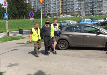 Zatrzymany mężczyzna w towarzystwie policjantów