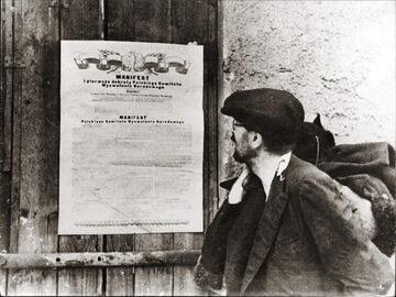 Zdjęcie propagandowe przedstawiające osobę czytającą Manifest PKWN