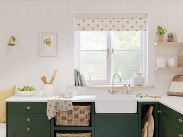 Zielona zabudowa kuchenna w rustykalnym stylu. Zestawiona z bielą nie zaciemnia wnętrza