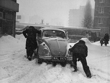 Zima Stulecia na Wierzbnie w Warszawie. Mężczyźni pchający samochód Volkswagen Garbus