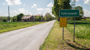 Znak drogowy informujący o wjeździe do Zakrzówka z tabliczką doczepioną przez Barta Staszewskiego