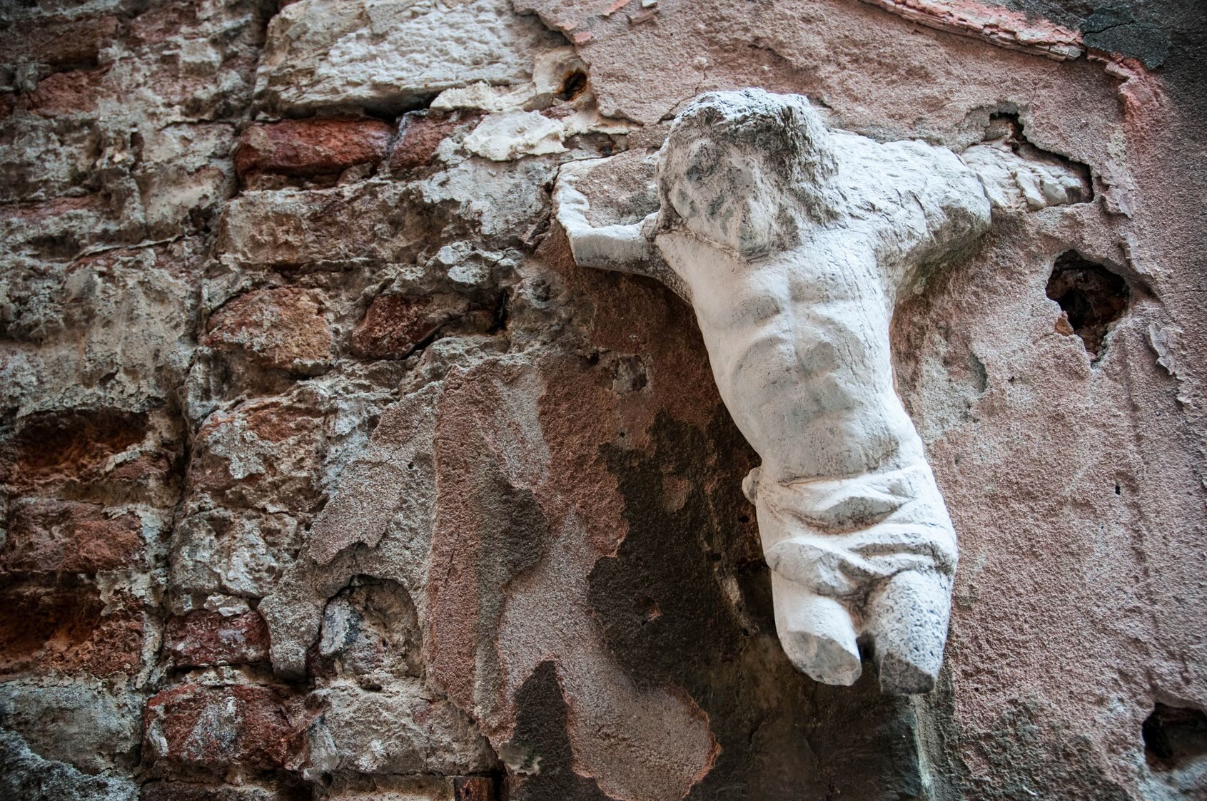 Zniszczona figura Jezusa na krzyżu
