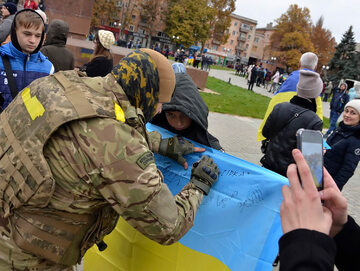 Żołnierz podpisujący ukraińską flagę