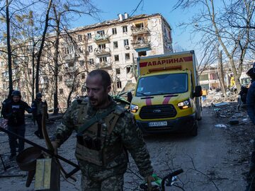 Żołnierz torujący drogę karetce z cywilami po ostrzale Kijowa, 18 marca