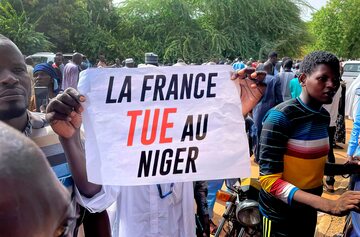 Zwolennicy junty podczas protestu, który odbył się 30 lipca przed francuską ambasadą w Niamey. Widoczne hasło oznacza „Francja zabija w Nigrze”